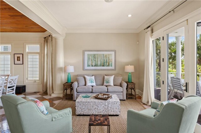 living room with a healthy amount of sunlight, ornamental molding, and ornate columns