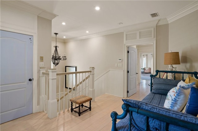 interior space with light hardwood / wood-style floors, a notable chandelier, and ornamental molding