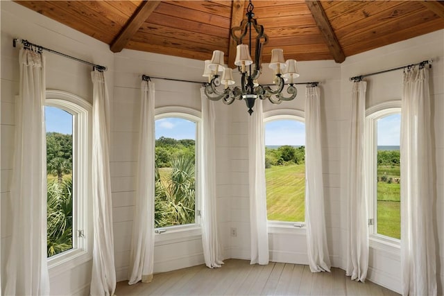 unfurnished sunroom with a healthy amount of sunlight and wooden ceiling