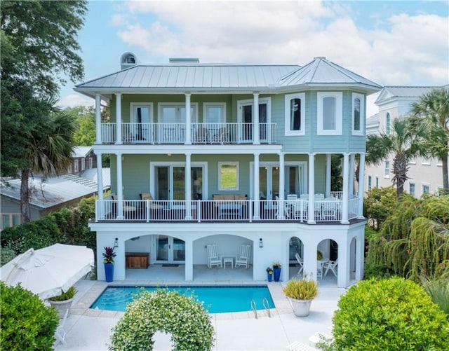 rear view of property with a patio area, a balcony, and french doors