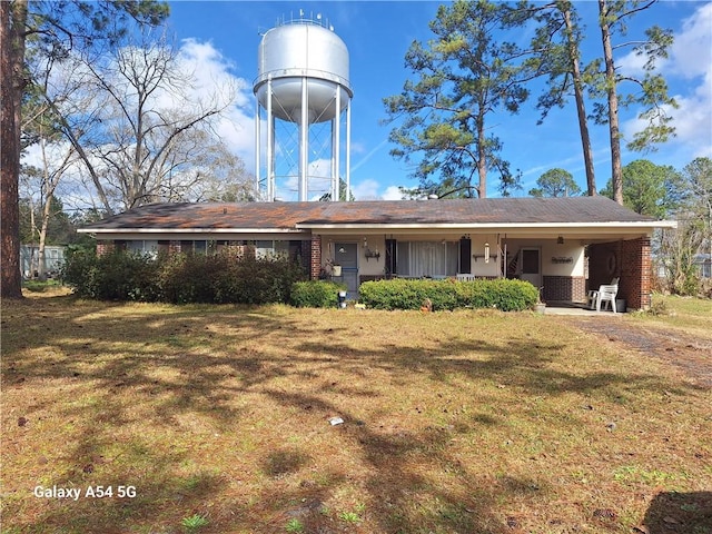 view of front of home with brick siding and a front lawn