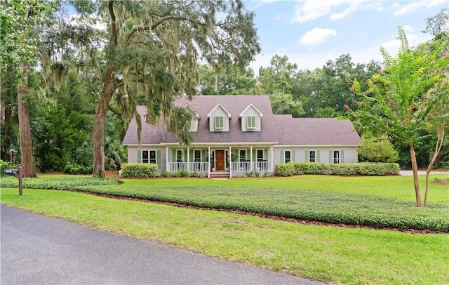 cape cod-style house with covered porch and a front lawn