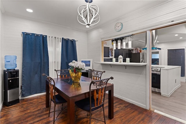 dining space with dark hardwood / wood-style floors, ornamental molding, and a chandelier