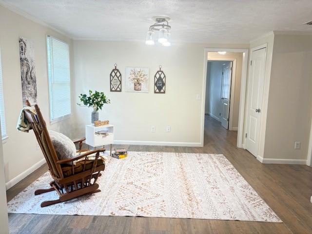 living area featuring baseboards, visible vents, and wood finished floors