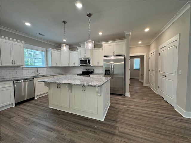 193 W Melody Dr, Jesup, GA 31545 - kitchen with appliances with stainless steel finishes, crown molding, a kitchen island, white cabinetry, and backsplash