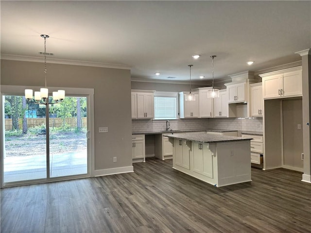 193 W Melody Dr, Jesup, GA 31545 - kitchen featuring a center island, healthy amount of natural light, dark wood-style flooring, decorative backsplash, and crown molding