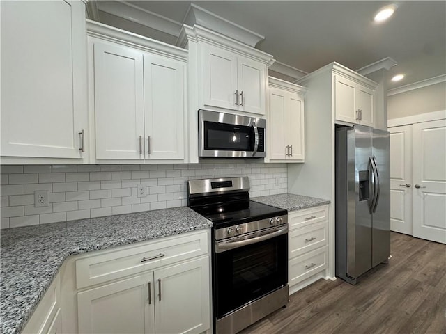 193 W Melody Dr, Jesup, GA 31545 - kitchen featuring appliances with stainless steel finishes, crown molding, white cabinetry, decorative backsplash, and dark wood-type flooring