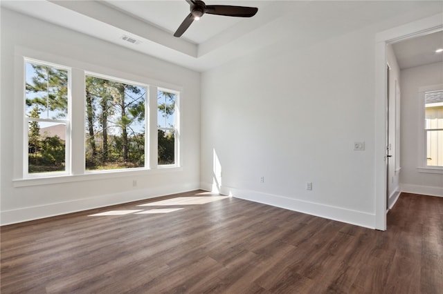 empty room with plenty of natural light, dark hardwood / wood-style floors, and ceiling fan