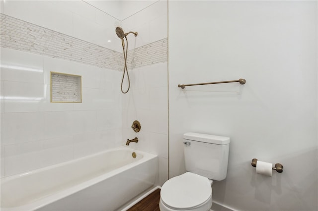 bathroom with toilet and tiled shower / bath