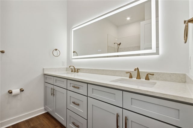 bathroom with a shower, hardwood / wood-style floors, and vanity