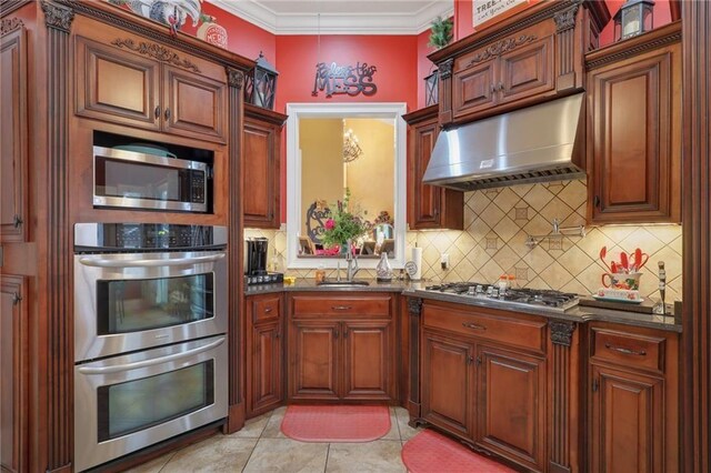 655 Littlefield St, Jesup, GA 31546 - kitchen featuring range hood, stainless steel appliances, backsplash, crown molding, and light tile patterned floors