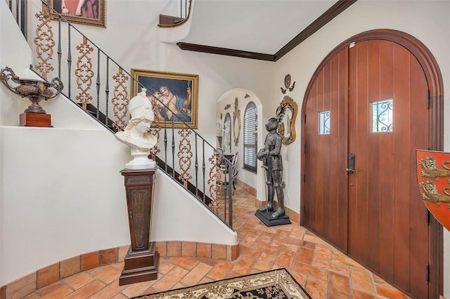 265 Harbor Pointe Dr, Brunswick, GA 31523 - foyer entrance with stone tile flooring, crown molding, stairway, baseboards, and arched walkways
