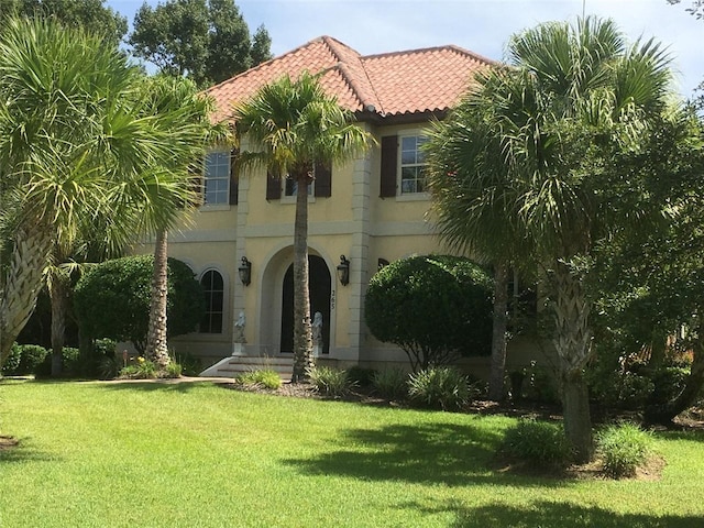 265 Harbor Pointe Dr, Brunswick, GA 31523 - mediterranean / spanish house with a tile roof, a front lawn, and stucco siding
