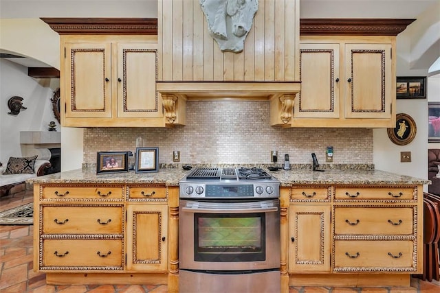 265 Harbor Pointe Dr, Brunswick, GA 31523 - kitchen featuring gas range, decorative backsplash, arched walkways, and light stone countertops
