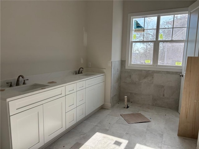 bathroom with vanity and tile walls