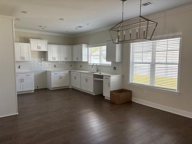 kitchen with pendant lighting, white cabinetry, and crown molding