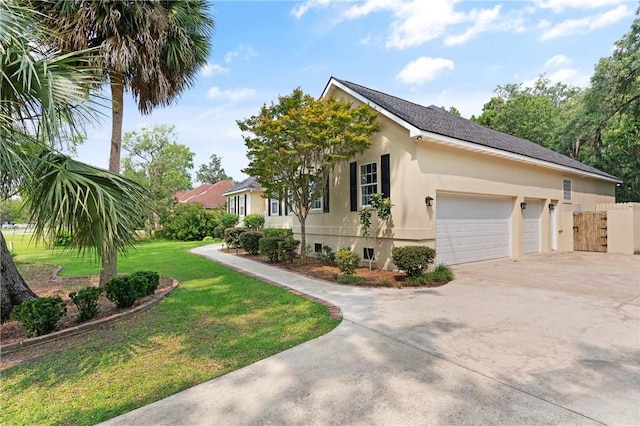 127 Clipper Bay Rd, Brunswick, GA 31523 - view of side of property with driveway, an attached garage, and stucco siding