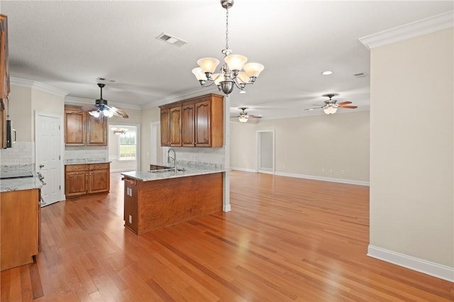 127 Clipper Bay Rd, Brunswick, GA 31523 - kitchen with ceiling fan, brown cabinets, a chandelier, light wood finished floors, and a peninsula