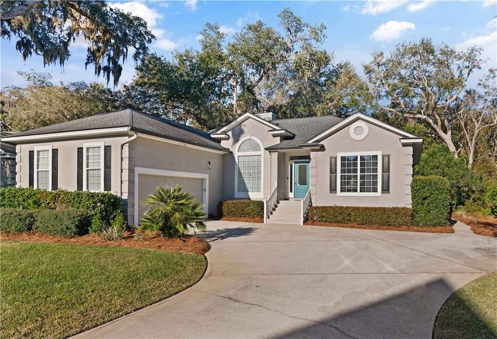 ranch-style home with a garage and a front yard