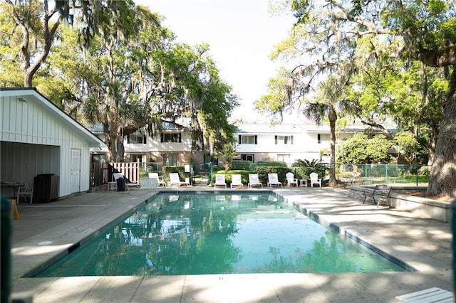 community pool featuring fence and a patio