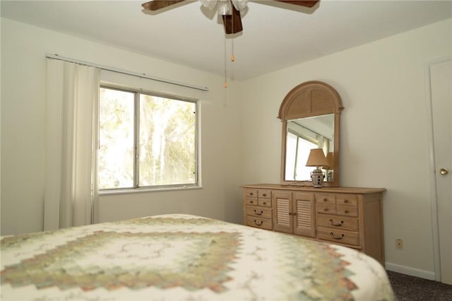 bedroom with multiple windows, ceiling fan, carpet flooring, and baseboards