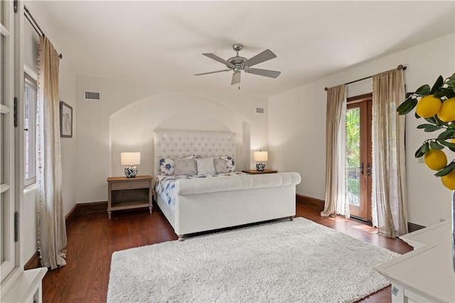 bedroom featuring baseboards, visible vents, arched walkways, and wood finished floors