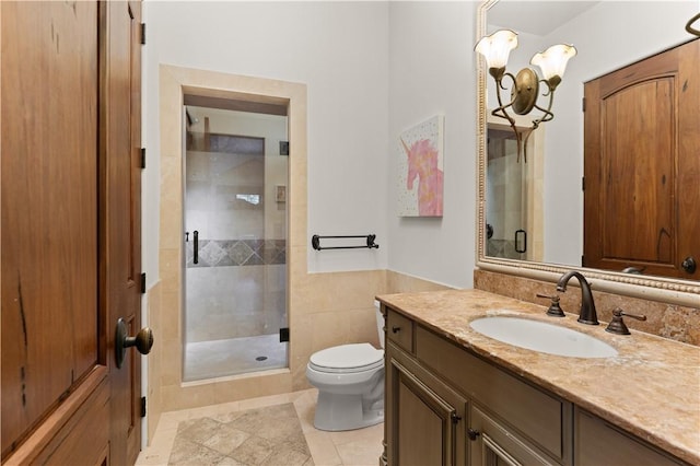 bathroom featuring a chandelier, a shower stall, toilet, and vanity
