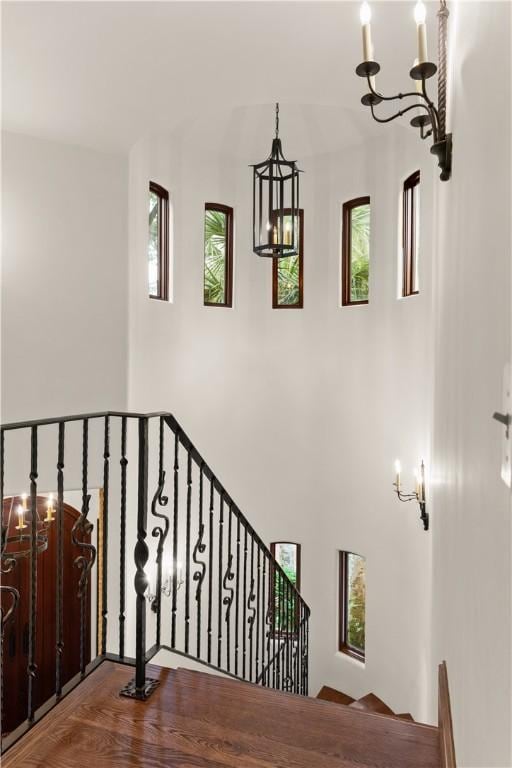 stairway featuring a chandelier and wood finished floors