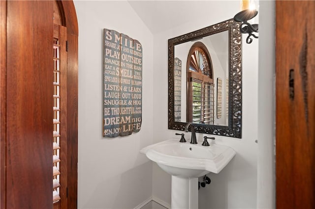 bathroom featuring baseboards and lofted ceiling