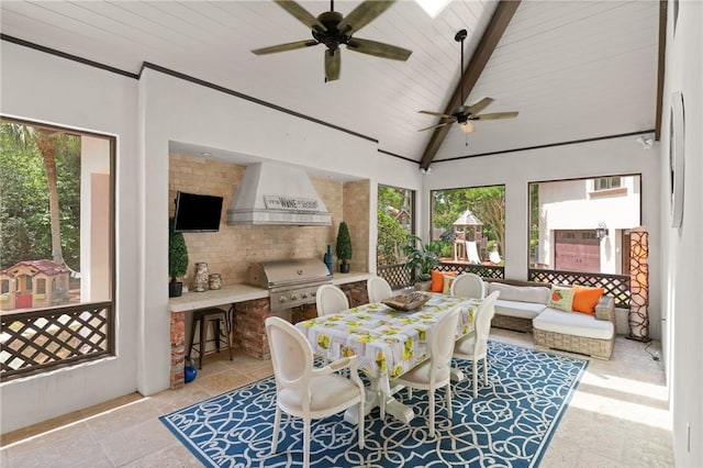 dining room featuring beamed ceiling, stone tile floors, ceiling fan, and high vaulted ceiling