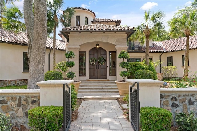 property entrance with stucco siding and a tile roof