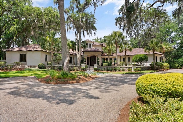 mediterranean / spanish-style house featuring a tile roof and stucco siding