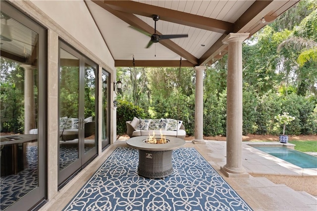view of patio / terrace with an outdoor fire pit, a ceiling fan, and an outdoor pool