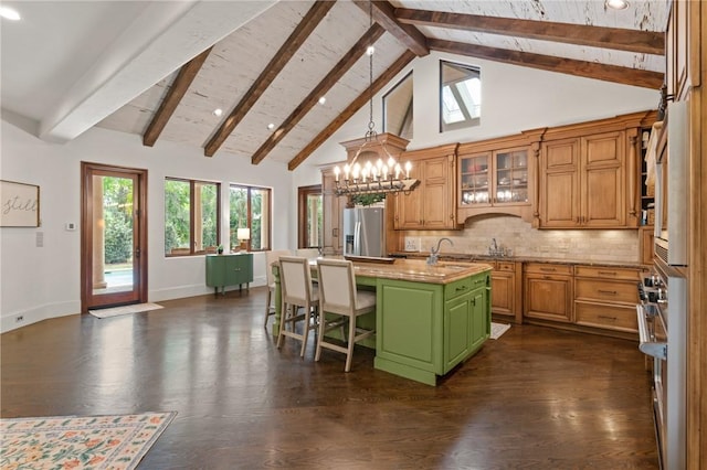 kitchen with beamed ceiling, an inviting chandelier, dark wood-style flooring, stainless steel refrigerator with ice dispenser, and an island with sink