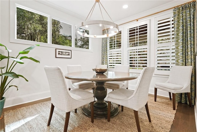 dining area featuring hardwood / wood-style flooring and an inviting chandelier