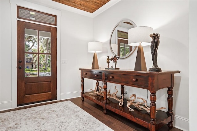 foyer entrance with dark hardwood / wood-style flooring and ornamental molding