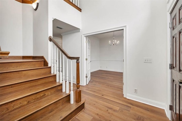 entryway with a high ceiling, an inviting chandelier, and light hardwood / wood-style flooring