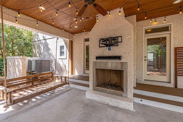 view of patio / terrace featuring ceiling fan, cooling unit, and an outdoor fireplace