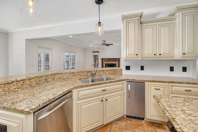 kitchen featuring sink, stainless steel appliances, decorative light fixtures, and cream cabinetry