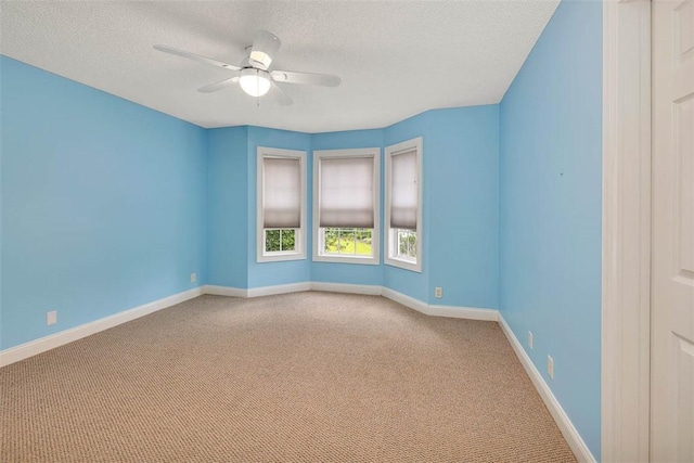 carpeted empty room featuring ceiling fan and a textured ceiling