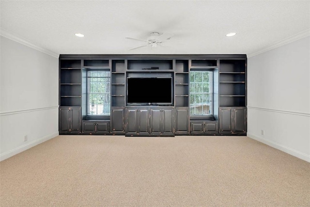 unfurnished living room featuring carpet flooring, ceiling fan, and crown molding