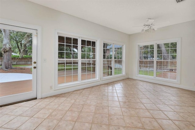 unfurnished sunroom featuring ceiling fan