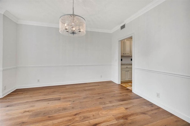 unfurnished room with a chandelier, light wood-type flooring, and crown molding