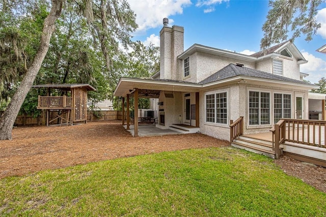 back of house featuring a yard, a patio area, and a wooden deck