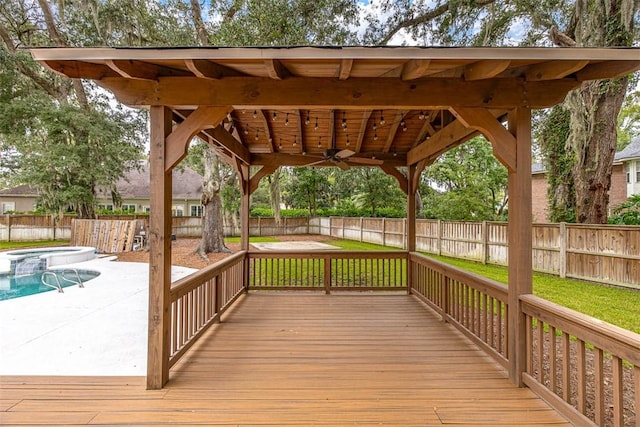 deck featuring ceiling fan and a fenced in pool