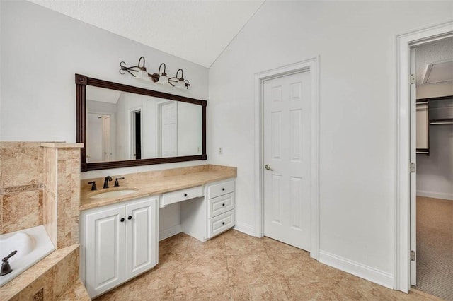 bathroom with tile patterned floors, vanity, a textured ceiling, tiled bath, and lofted ceiling