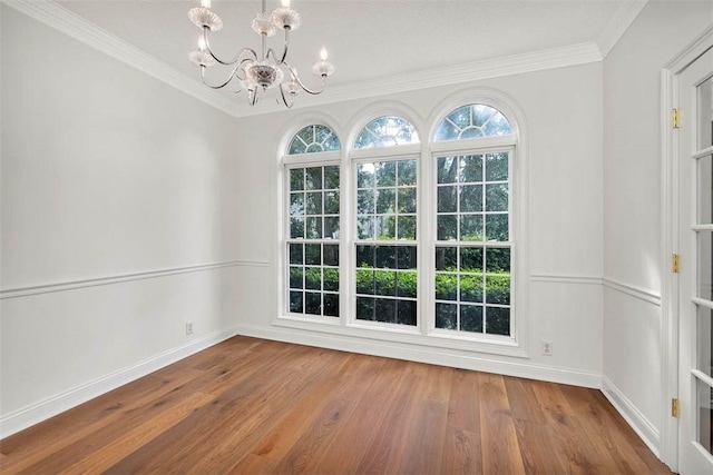 unfurnished dining area with hardwood / wood-style flooring, a notable chandelier, and crown molding