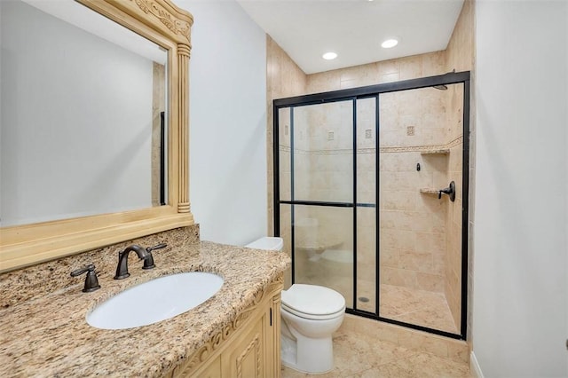 bathroom with tile patterned floors, vanity, toilet, and a shower with door