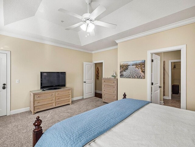 carpeted bedroom with a tray ceiling, ceiling fan, crown molding, and a textured ceiling