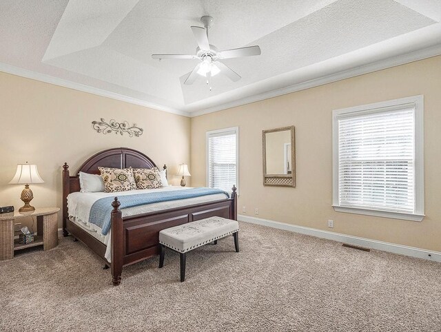 bedroom featuring carpet floors, a raised ceiling, ceiling fan, and ornamental molding